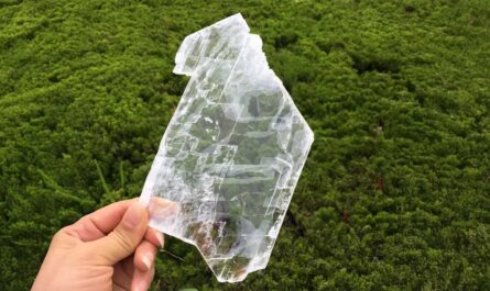 A woman holding a large crystal to show the spiritual benefits of selenite