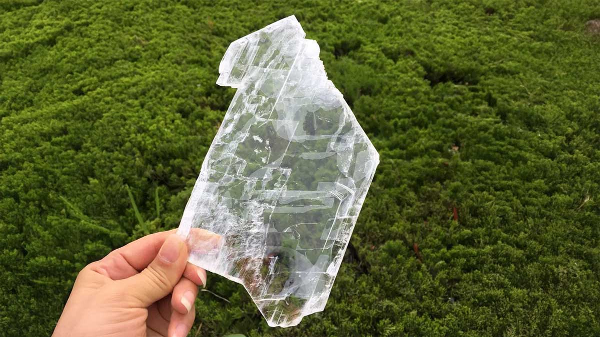 A woman holding a large crystal to show the spiritual benefits of selenite