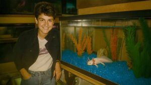 Avia next to the axolotl in the pet store she worked at